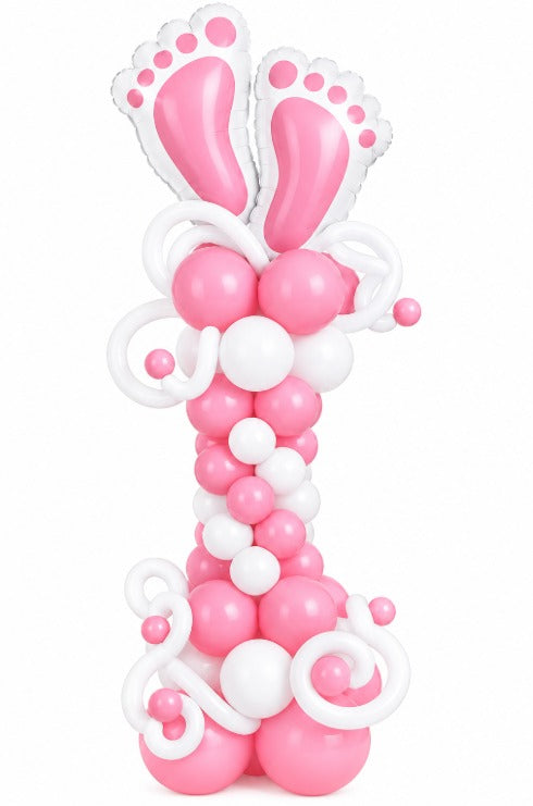 Pink and white balloon column topped with two baby feet foil balloons