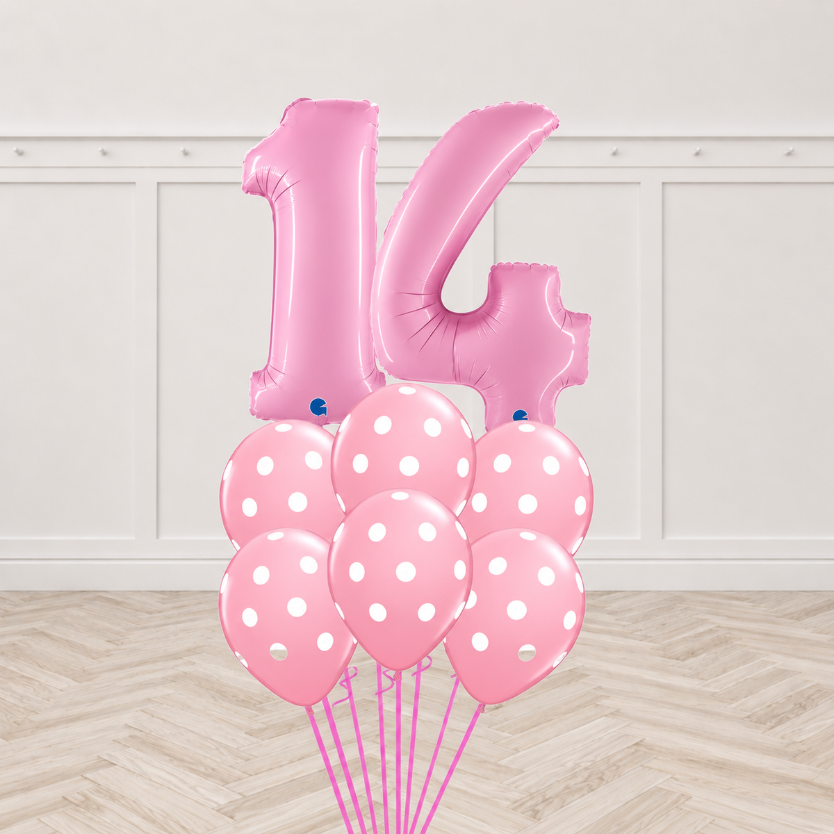 Two pink number foil balloons forming a two-digit age with six pink polka-dot latex balloons