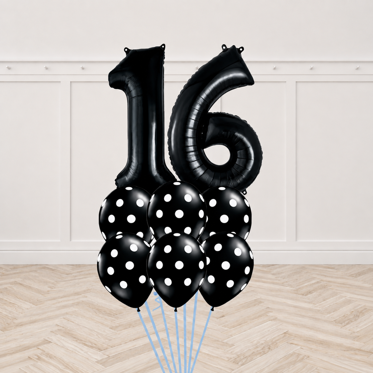 Two black number foil balloons forming a two-digit age with six black polka-dot latex balloons