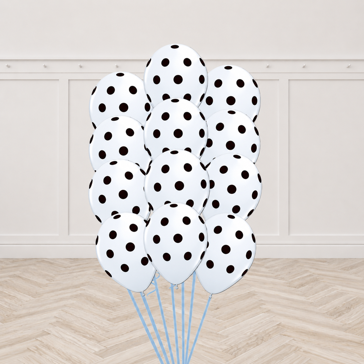 Twelve white latex balloons printed with black polka dots, tied together in a bouquet