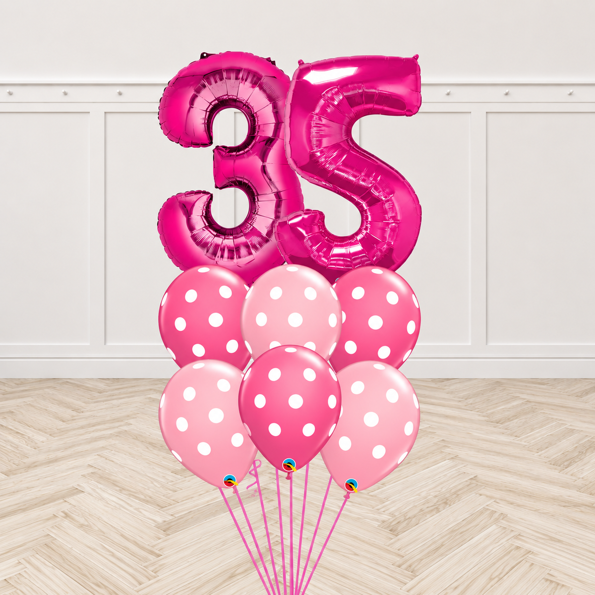 Two magenta number foil balloons forming a two-digit age with six two-tone pink polka-dot latex balloons