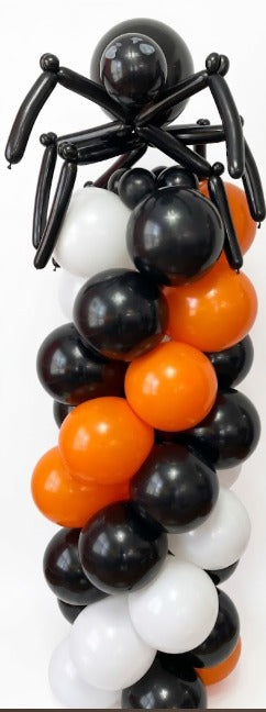 Halloween balloon column in black, orange and white topped with a large black spider balloon figure