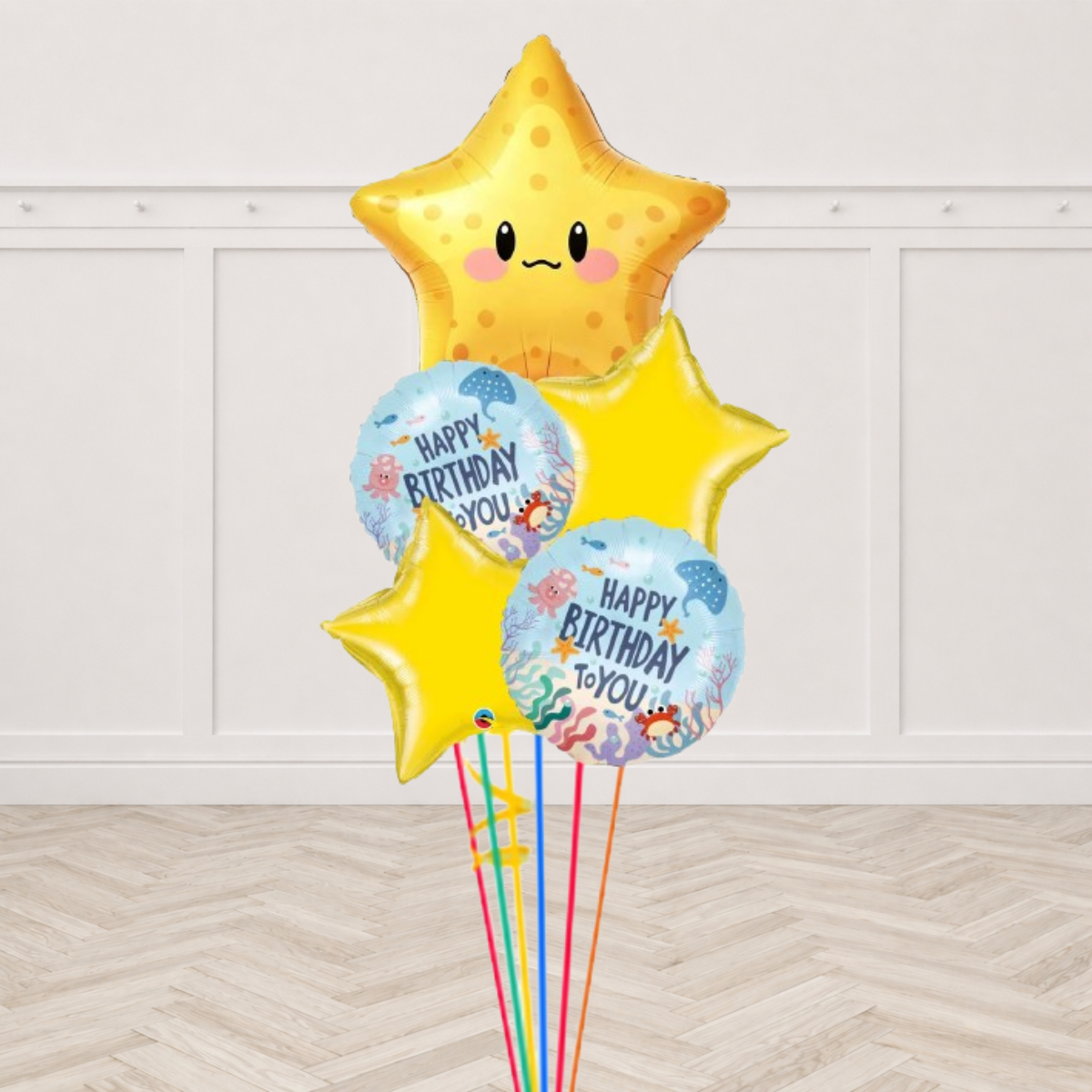Smiling starfish foil balloon with under the sea Happy Birthday rounds and yellow stars