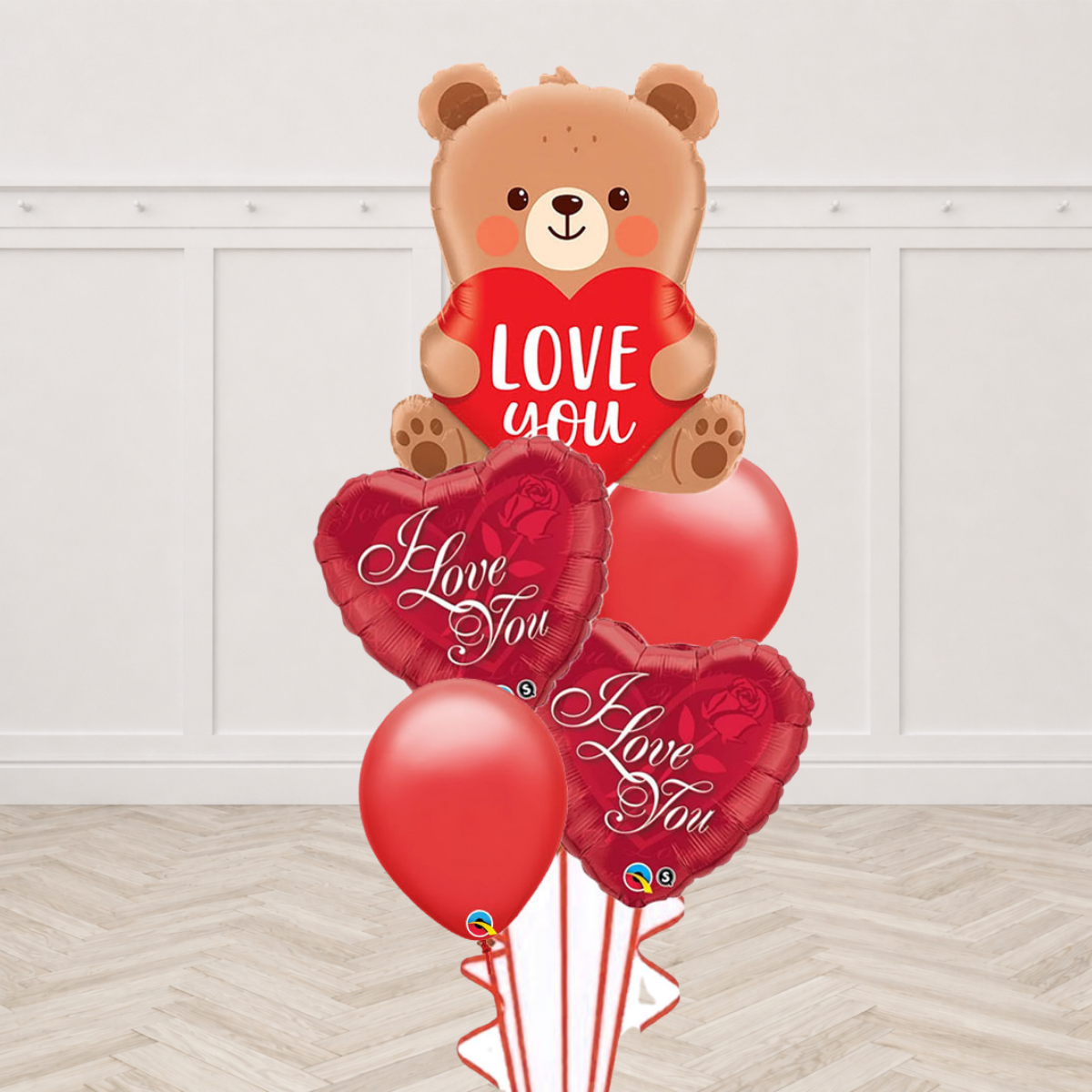 Teddy bear foil balloon holding a Love You heart with I Love You heart foil balloons and red latex balloons