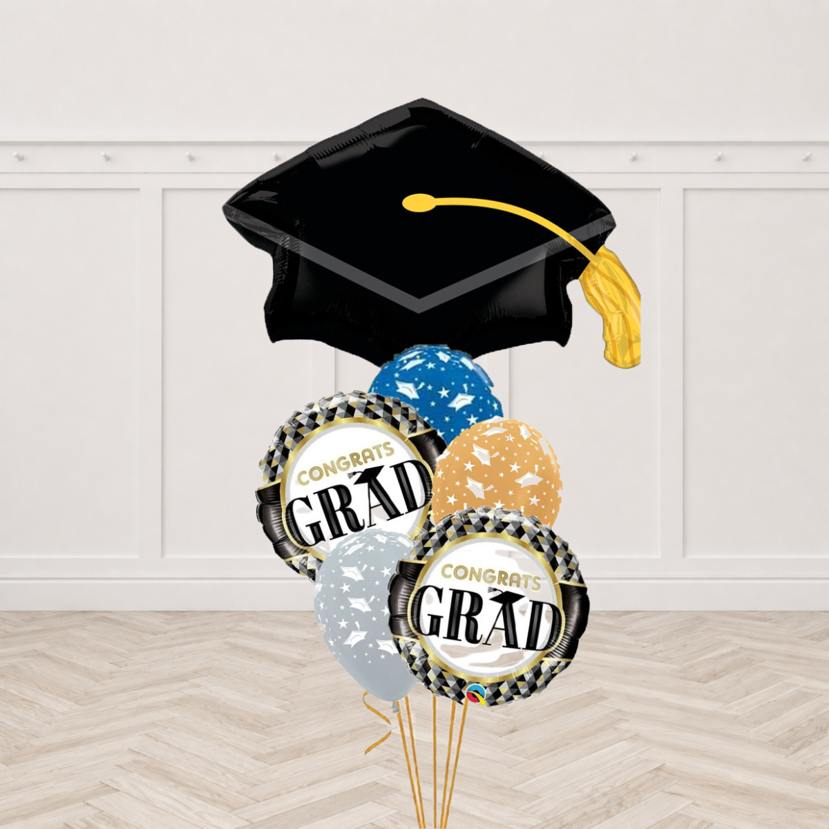 Black graduation cap shaped foil balloon with two black and gold checkered Congrats Grad round foils and three blue, gold and silver latex balloons