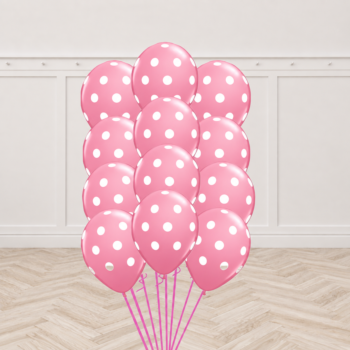 Twelve pink latex balloons printed with white polka dots, tied together in a bouquet