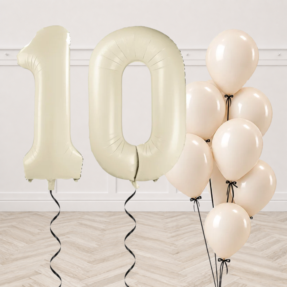 Cream number 1 and 0 foil balloons with a bunch of white latex balloons tied with black ribbons and bows